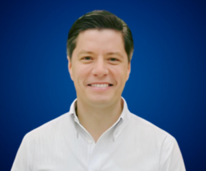 Retrato de Pablo Hurtado, conferencista y mentor en ventas y liderazgo comercial, con fondo azul.